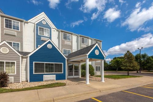 a house with a blue and white house at Microtel Inn & Suites by Wyndham Sioux Falls in Sioux Falls