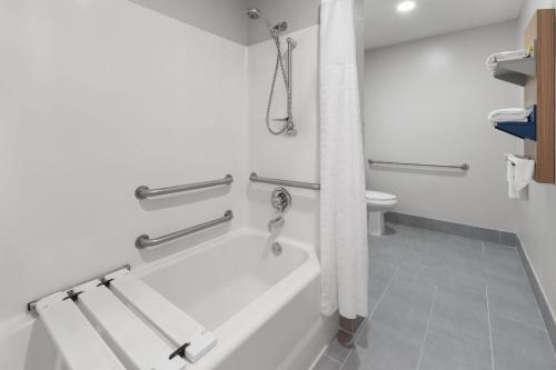 a bathroom with a bath tub and a toilet at Microtel Inn & Suites by Wyndham Sioux Falls in Sioux Falls
