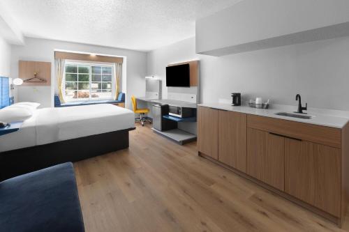 a hotel room with a bed and a kitchen at Microtel Inn & Suites by Wyndham Sioux Falls in Sioux Falls