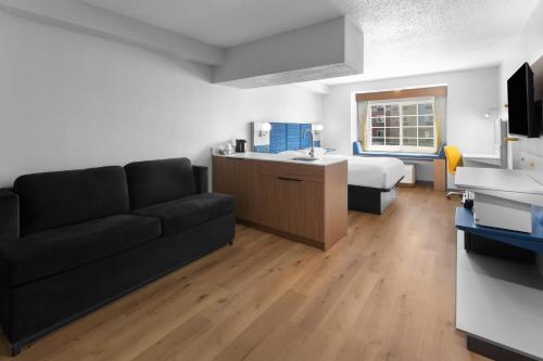 a living room with a couch and a bed at Microtel Inn & Suites by Wyndham Sioux Falls in Sioux Falls