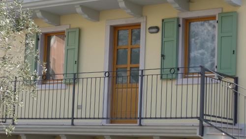 a house with green doors and a balcony at Casa Elisa in Pietramurata