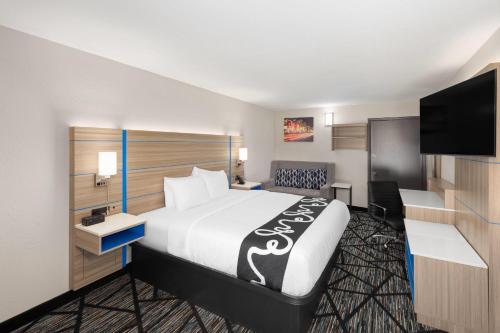 a hotel room with a bed and a flat screen tv at La Quinta Inn by Wyndham Nashville South in Nashville