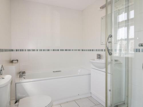 a bathroom with a tub and a toilet and a sink at Owls Roost in Saint Goran