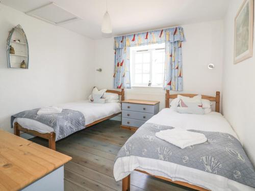 a bedroom with two beds and a window at Owls Roost in Saint Goran
