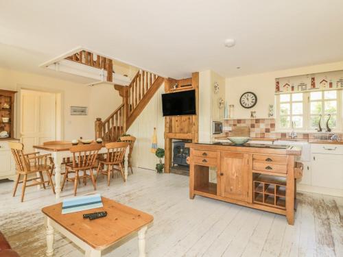 a kitchen and living room with a table and a dining room at Foxes Den in Saint Goran