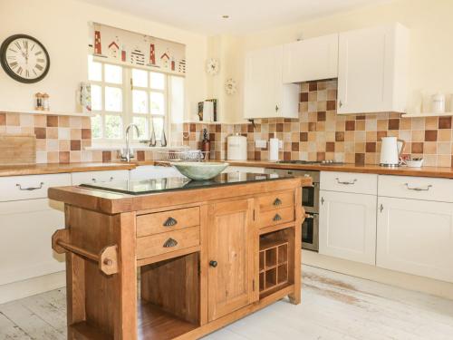 a kitchen with a wooden island with a sink at Foxes Den in Saint Goran