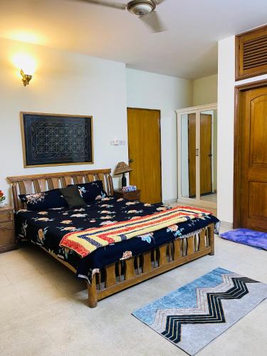 a bedroom with a large wooden bed in a room at Gulshan Elegant Center 3 BR AC Flat Near Cafes & Shops Heart of Gulshan in Dhaka