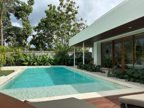 a swimming pool in the backyard of a house at Summa Villa - Tropical 2BR Villa w Big Pool in Selong Belanak