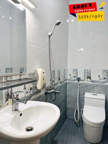 Un baño con lavabo, inodoro y espejo. en Khách sạn Thế Giới Mới - Thế Giới Mới Hotel, en Ho Chi Minh