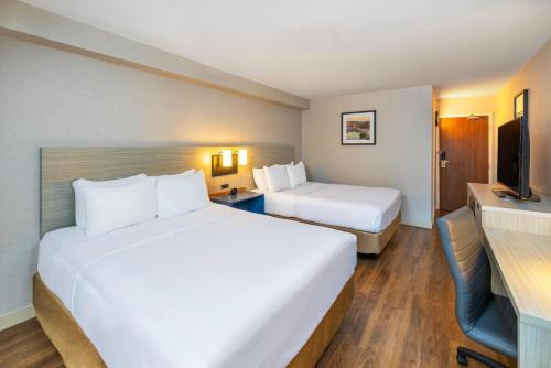 a hotel room with two beds and a television at Comfort Inn in Corner Brook