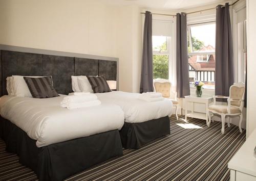 a hotel room with two beds and a window at The Guest House Broadstairs in Broadstairs