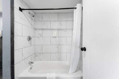 a bathroom with a shower and a tub and a toilet at Econo Lodge Cranston - Providence in Cranston