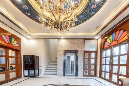 a living room with a chandelier and a staircase at Umrao Mahal Jaipur in Jaipur
