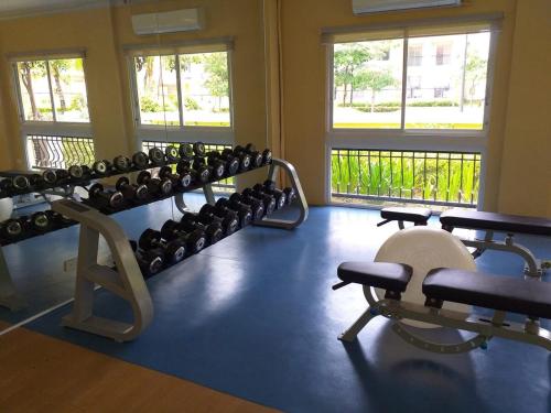 a gym with a lot of dumbbell racks and windows at 2BR Condo at Sanremo with Full Kitchen plus Free Fast&Unli Wi-Fi Complimentary Netflix plus Free Access to Pool in Cebu City