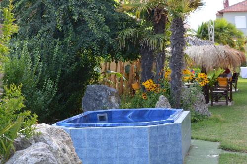 a blue bath tub in a garden with rocks at Lilalo Ηotel in Paralia Katerinis
