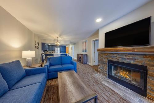 a living room with a blue couch and a fireplace at Park Plaza Resort - Park City, Ascend Collection Hotel in Park City