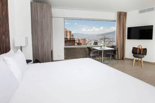 a hotel room with a bed and a view of a city at V Grand Hotel, a member of Radisson Individuals in Medellín