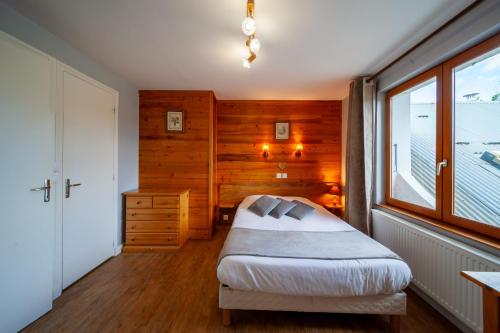 a bedroom with a bed and a window at Auberge des Montauds - Hôtel & Restaurant in Villard-de-Lans
