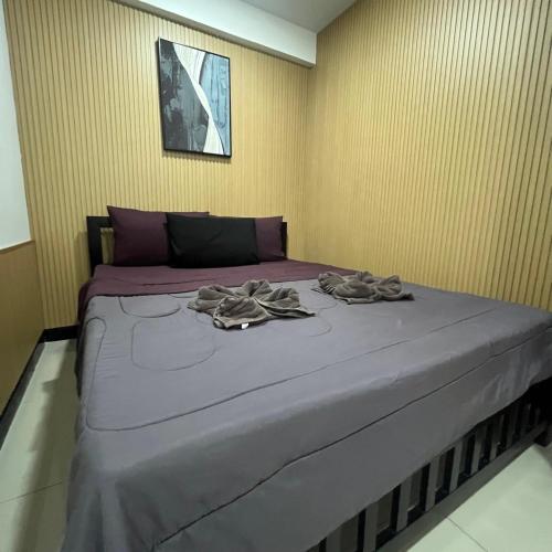a bed in a room with two towels on it at DonMueang station hotel in Ban Don Muang