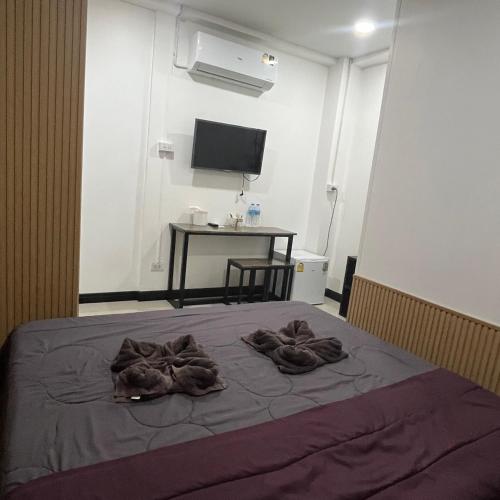 a bedroom with a bed with towels on it at DonMueang station hotel in Ban Don Muang