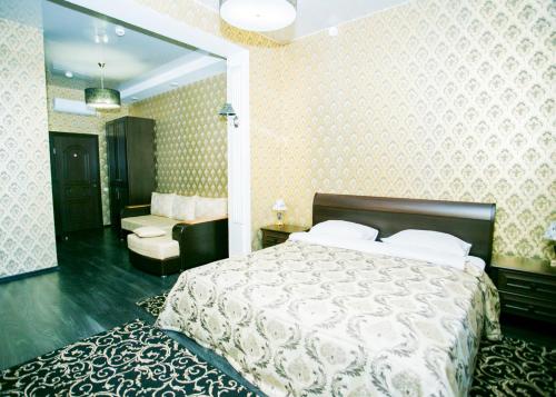 a bedroom with a bed and a chair and a mirror at Frant Hotel in Volgograd