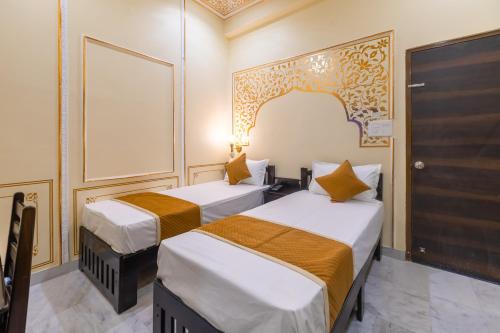 two beds in a hotel room with at Umrao Mahal Jaipur in Jaipur