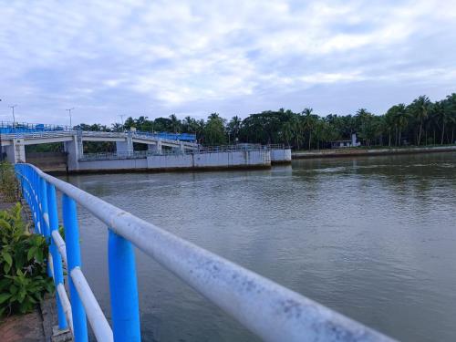 a bridge over a body of water with blue rails at Shruthi's Aarohi-Nature's Retreat Homestay in Kannur