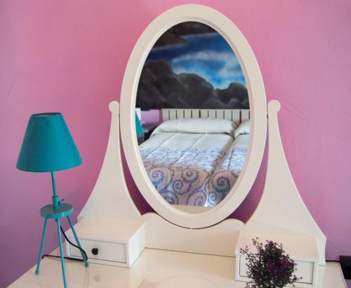 um quarto com uma cama num espelho redondo em Hotel Rural Casa Indie em Rabanal del Camino