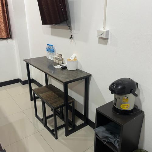 a small black table and stool in a room at DonMueang station hotel in Ban Don Muang