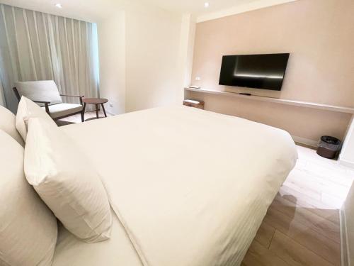a hotel room with a bed and a flat screen tv at Hotel Tainan in Tainan