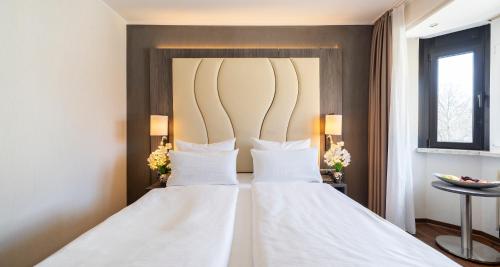 two white wedding dresses in a hotel room at PLAZA Hotel Buchhorner Hof in Friedrichshafen