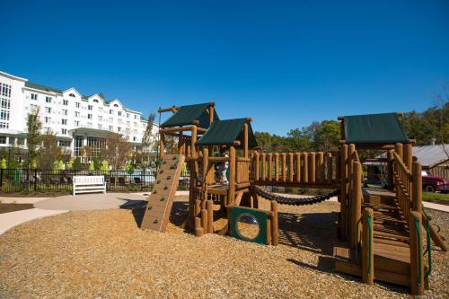 a park with a wooden playground with a slide at Dollywood's DreamMore Resort and Spa in Pigeon Forge