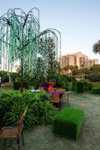 a garden with tables and chairs and a roller coaster at Hyatt Regency Grand Cypress Resort - Free Shuttle to Theme Parks! in Orlando