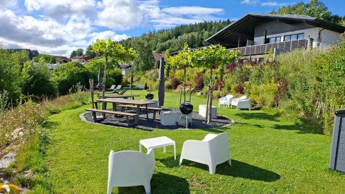 a park with a picnic table and white chairs at BayVista, die Bayerwald Lodge in Lam