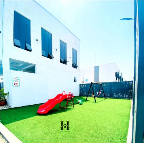 a playground with a red slide and a swing at OTMO Haven in Lagos