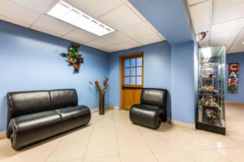 a waiting room with black leather chairs and blue walls at Rodeway Inn & Suites Fort Lauderdale Airport & Cruise Port in Fort Lauderdale