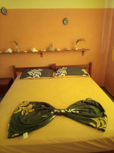 a bedroom with a bed with a green scarf on it at Ecoposada Quinta Le Palme in Chichiriviche