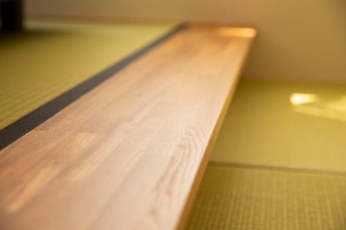 a close up of a wooden table in a room at RouTe5 in Matsumoto