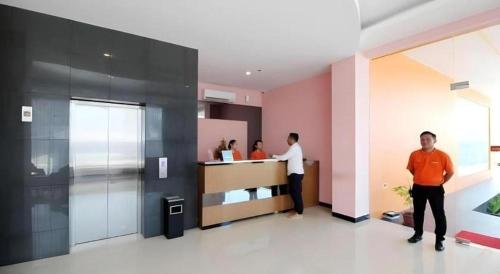 two men standing in a lobby with a counter at Sakura Manado in Manado