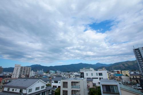 a view of a city with mountains in the background at RouTe5 in Matsumoto