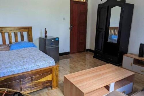a bedroom with a bed and a dresser and a mirror at Banana Grove Retreat in Shiri