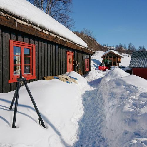 a pile of snow in front of a cabin at Restored Cabin From 1852 In Bergsjø Area in Skarsgård