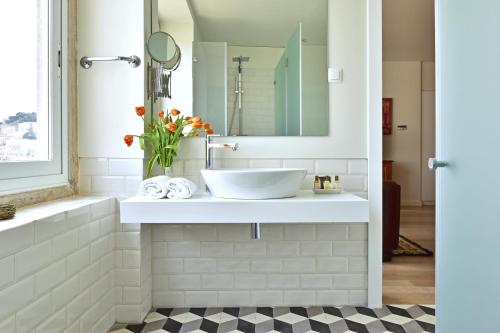 a bathroom with a sink and a mirror at Casa Balthazar in Lisbon