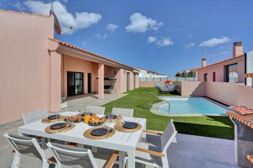 a patio with a table and chairs and a pool at Golden dunes villa picasso in Costa de Antigua