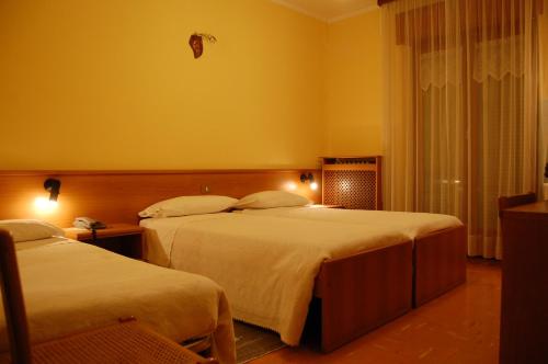 a hotel room with two beds and a window at Albergo Motel Dosdè B&B in Grosio