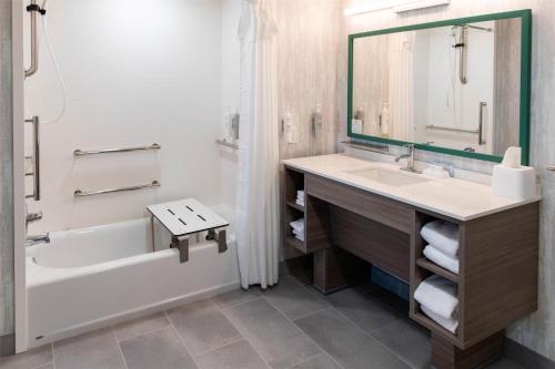 ein Badezimmer mit Waschbecken, Badewanne und Spiegel in der Unterkunft Home2 Suites By Hilton Effingham in Effingham