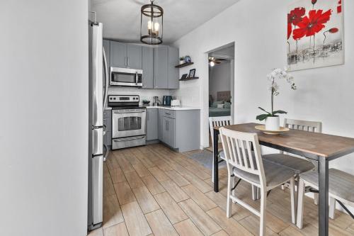 a kitchen with a table and a kitchen with a refrigerator at 4 Bedroom Modern Luxe Retreat with Hot Tub 5 Mins to Beach in West Palm Beach