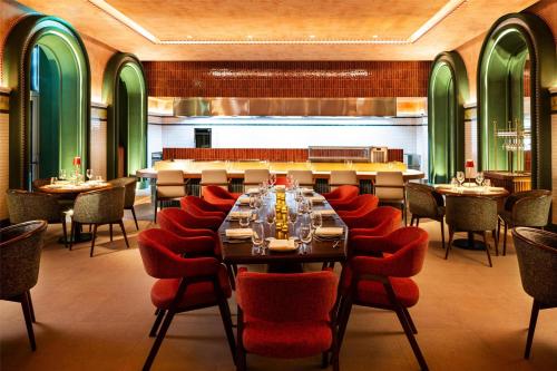a restaurant with a long table and red chairs at Hyatt Regency Zadar in Zadar