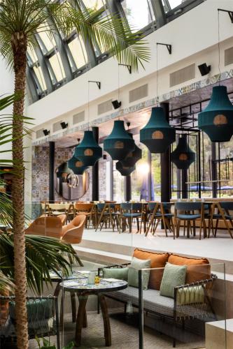 a lobby with a palm tree and tables and chairs at Hyatt Regency Zadar in Zadar