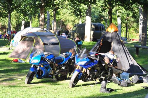 two motorcycles parked in the grass next to tents at Camping Noguera Pallaresa in Sort
